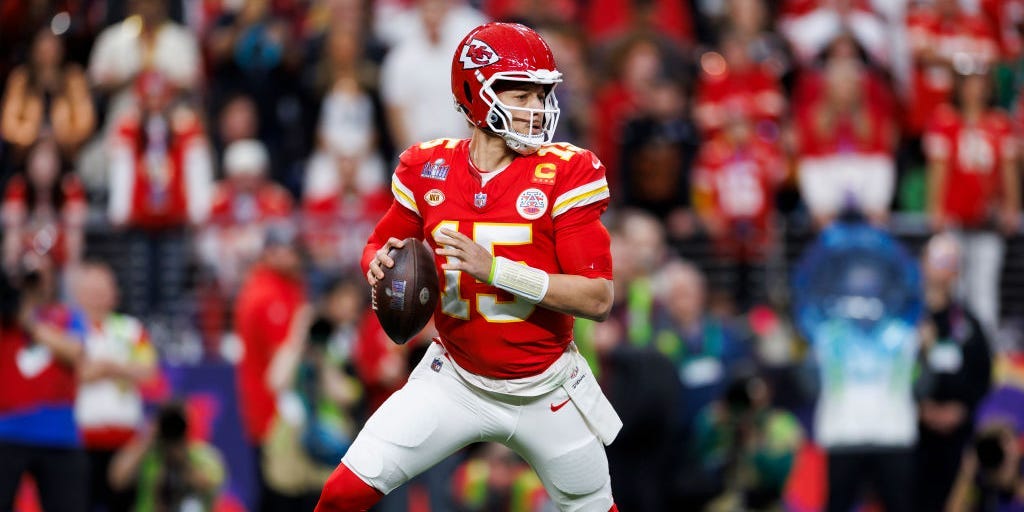 No. 15 Patrick Mahomes holding a football in a red jersey playing for the Kansas City Chiefs in the 2024 Super Bowl.