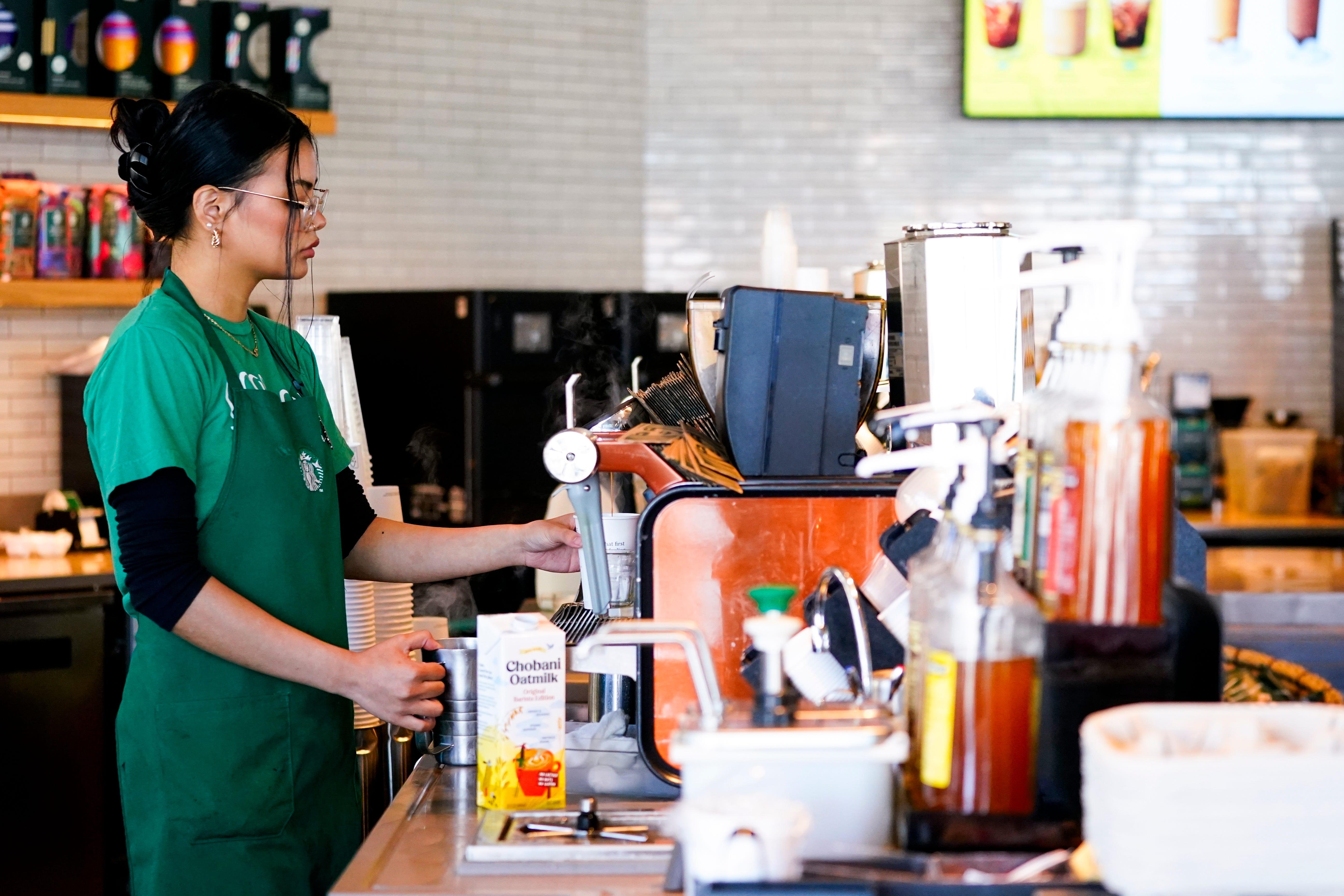 A Starbucks barista works at an espresso machine