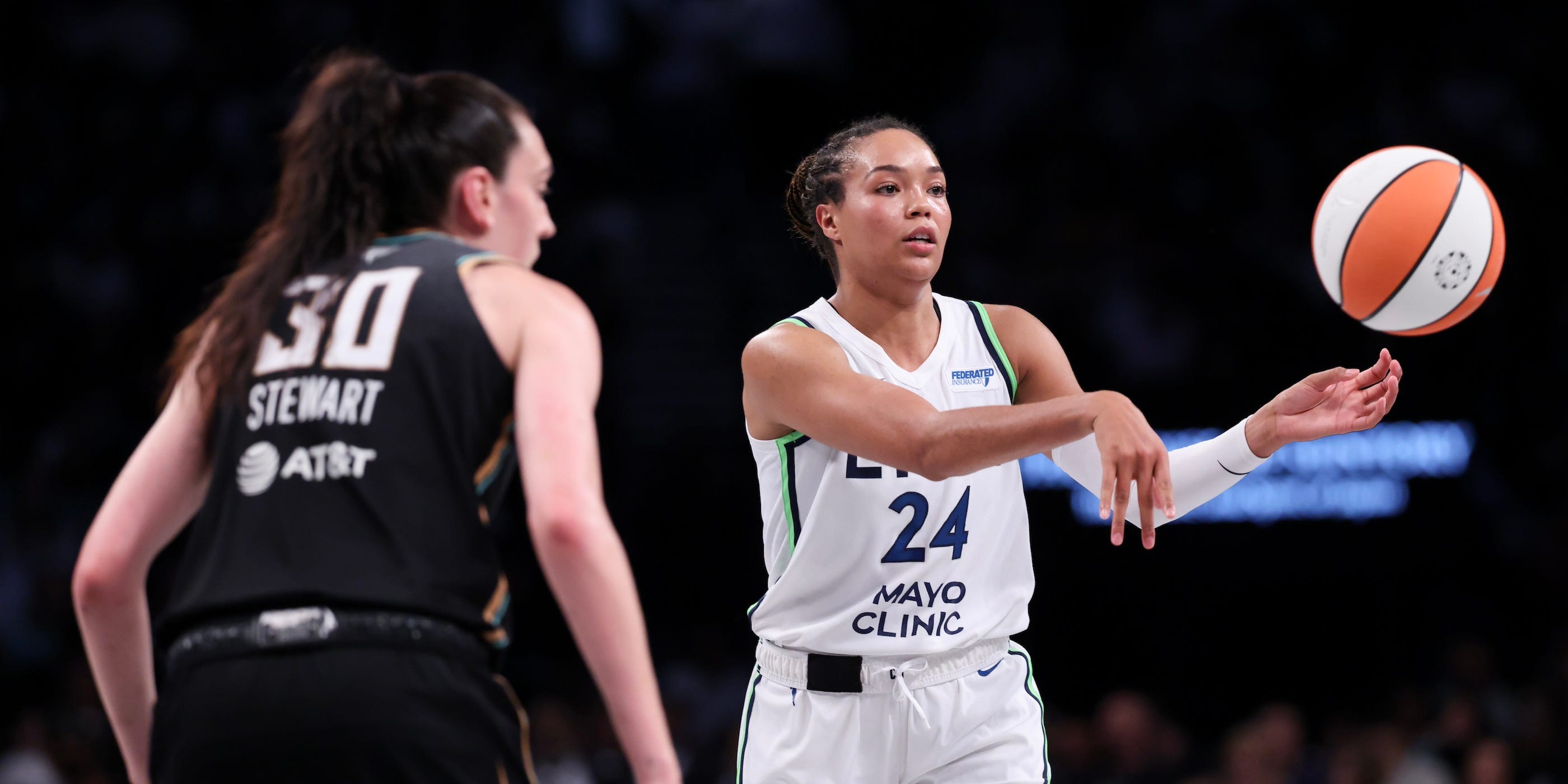 Napheesa Collier of the Minnesota Lynx passes the basketball while facing defender Breanna Stewart of the New York Liberty in Game 2 of the 2024 WNBA Finals.