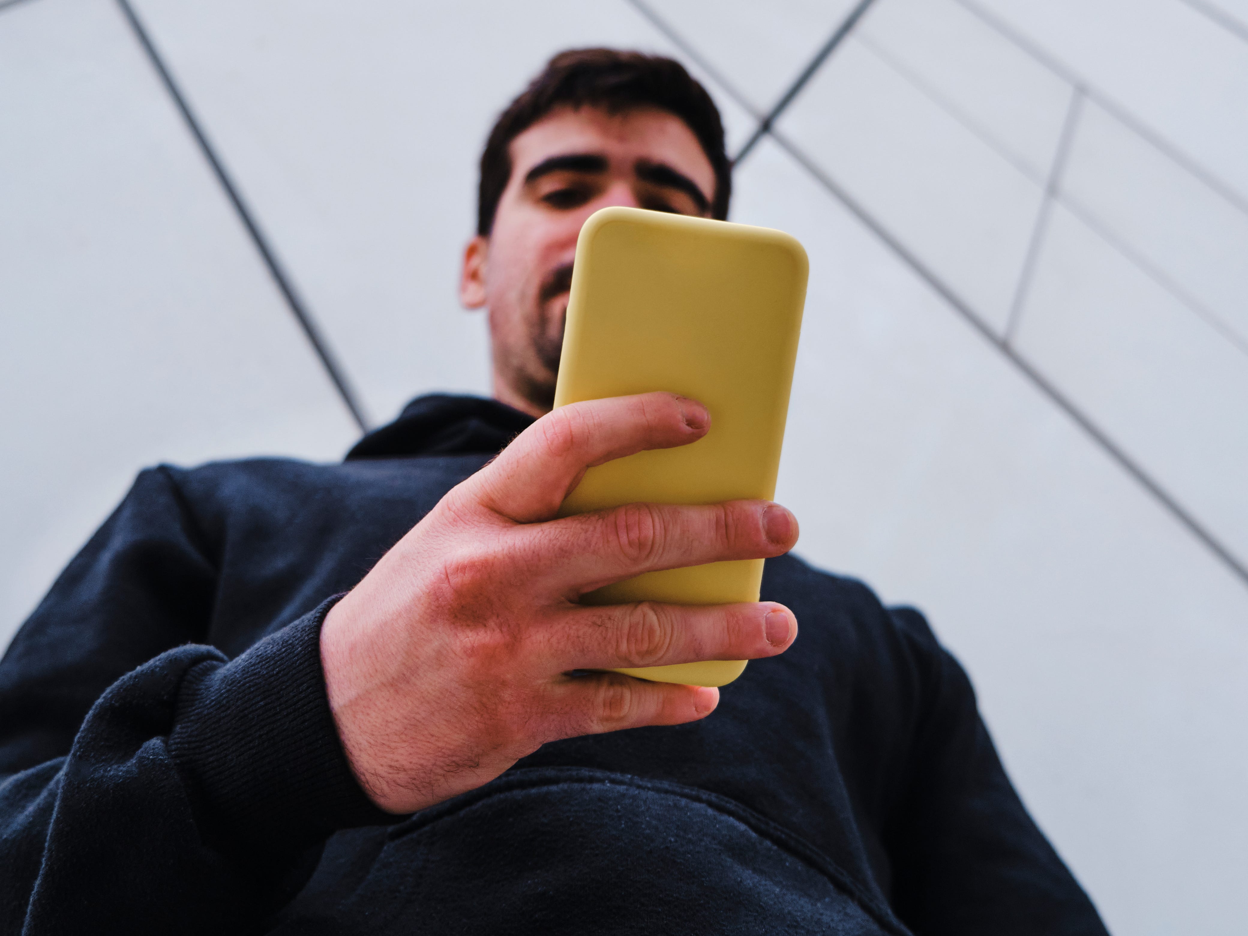 a tall man looking at his phone