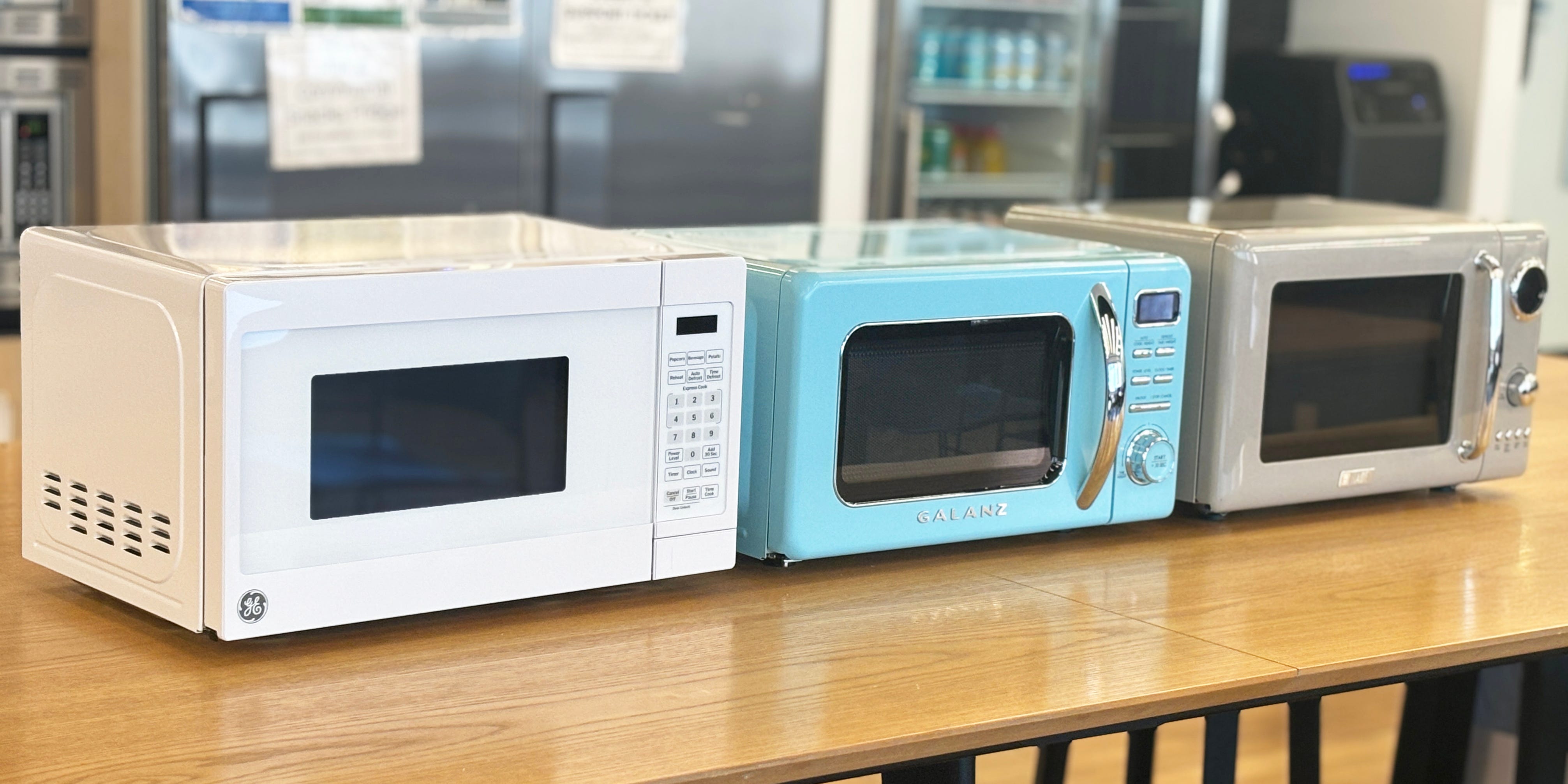 Three small microwaves on a countertop.